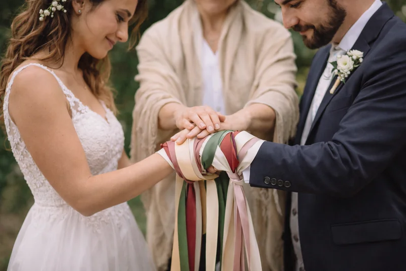 Pareja realizando ritual de unión de manos durante una ceremonia simbólica de matrimonio en Chile